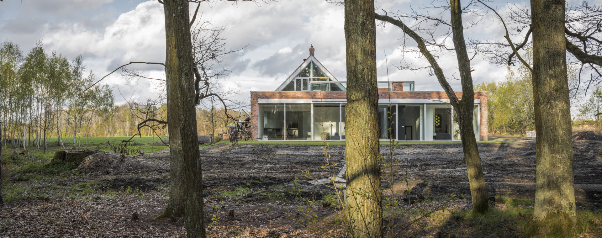 Widok z lasu na ceglany dom